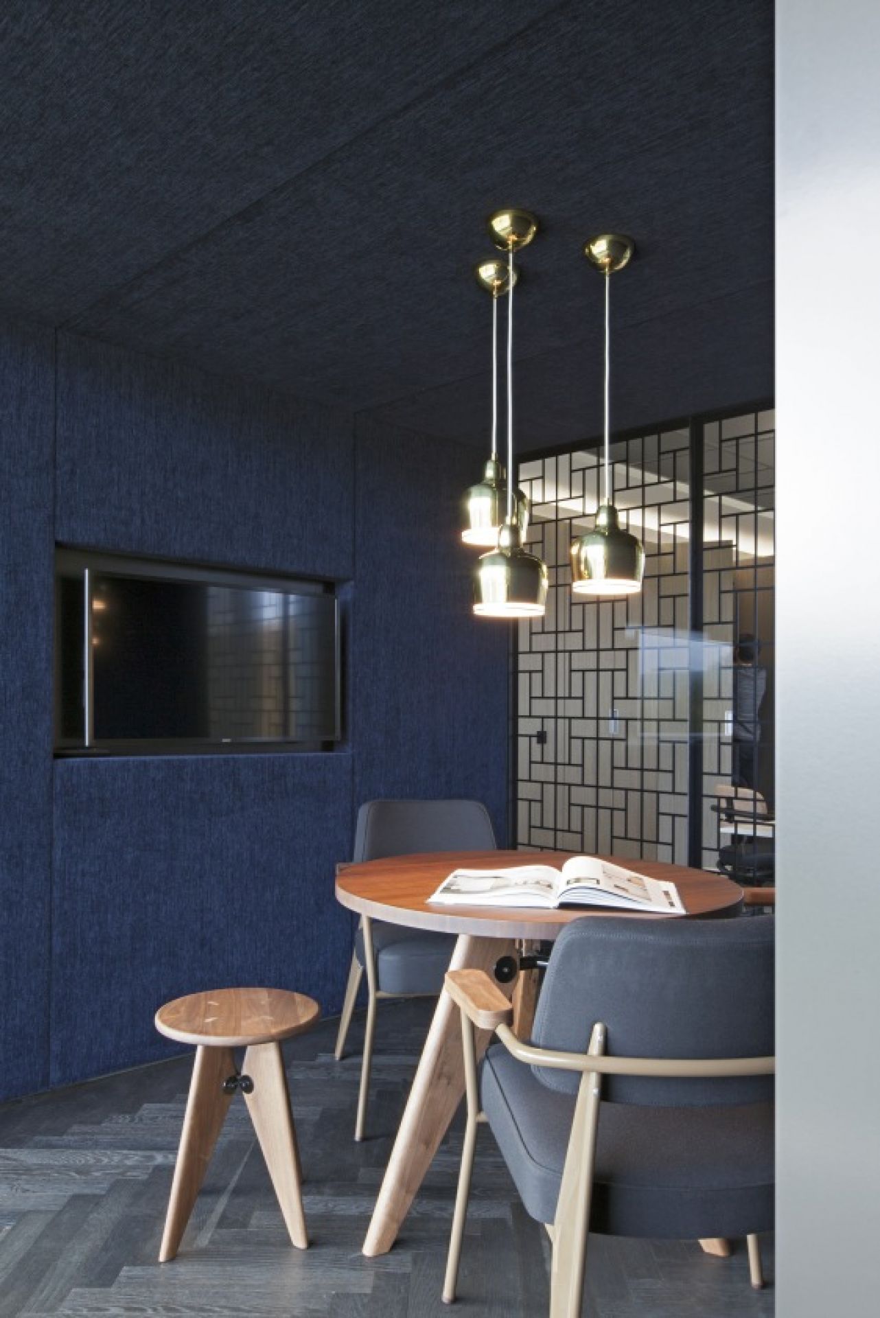 Runder Gueridon Tisch von Vitra mit Stühlen und Hocker in blauem Raum.