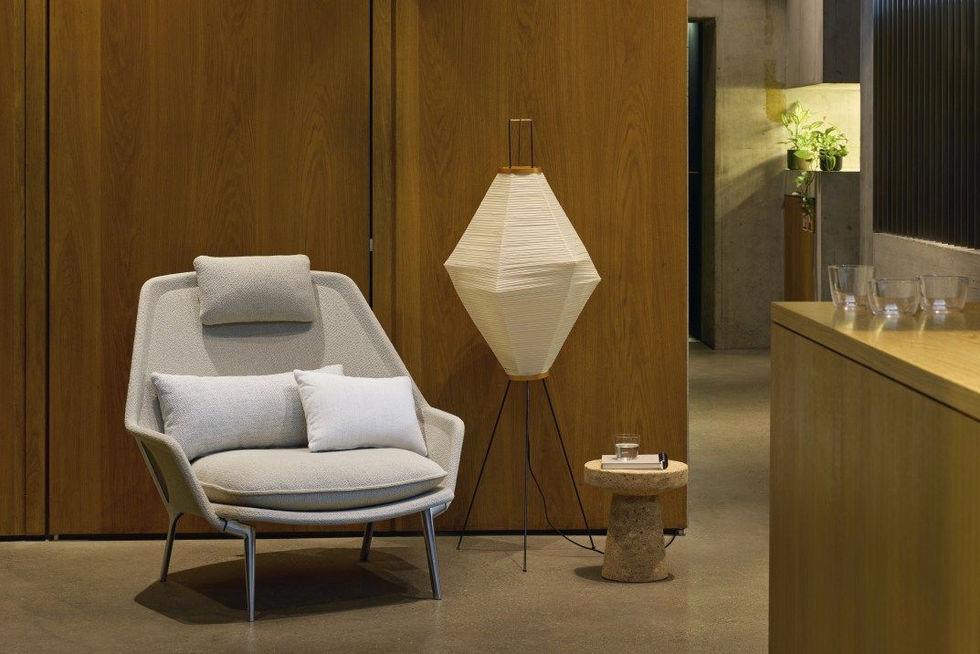 Vitra Slow Chair Sessel mit Stoffbezug in hellgrau, inklusive Kissen und Kopfstütze.