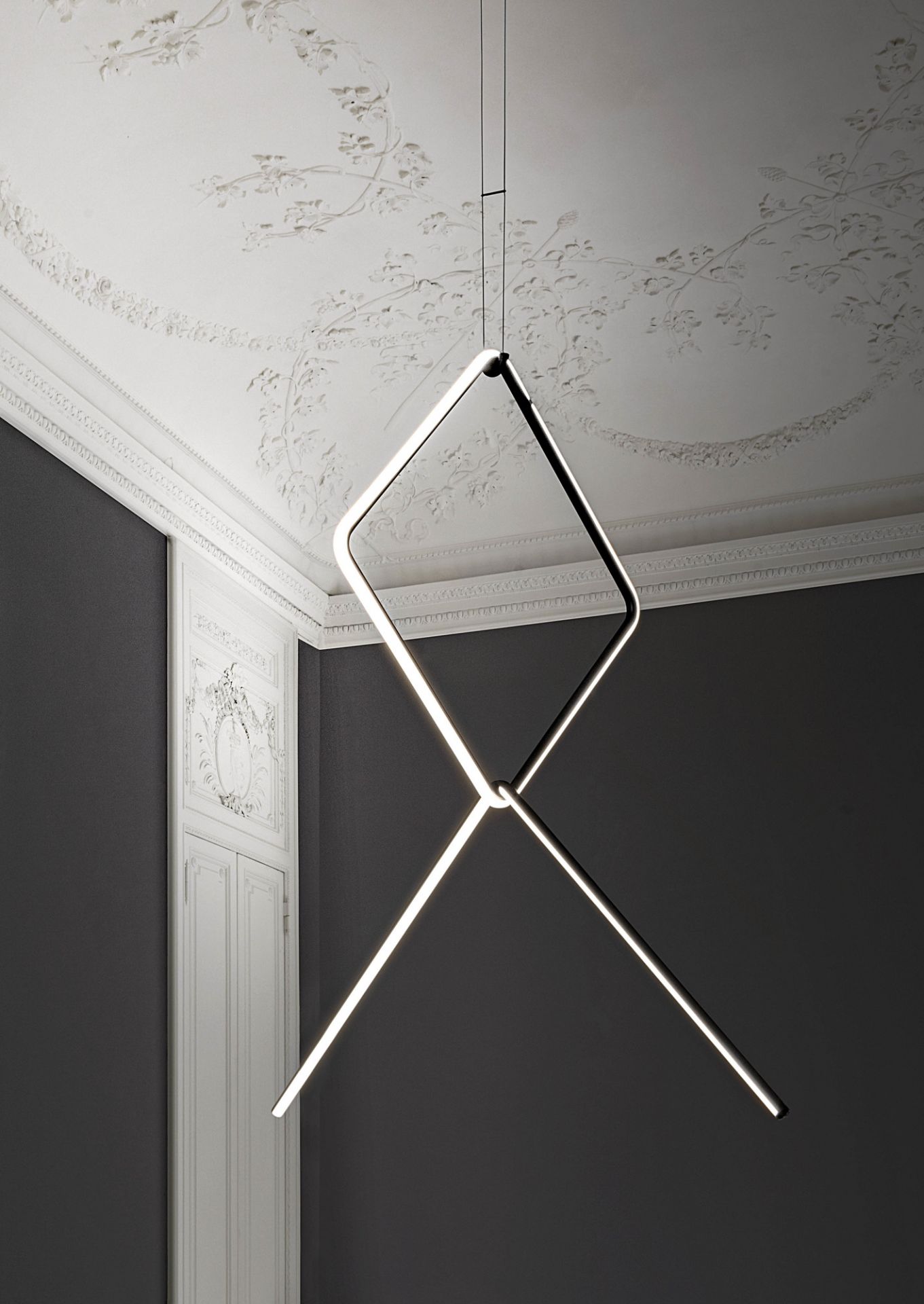 Flos Arrangements Pendelleuchte mit geometrischem Design aus leuchtenden Linien, die von der Decke hängen.
