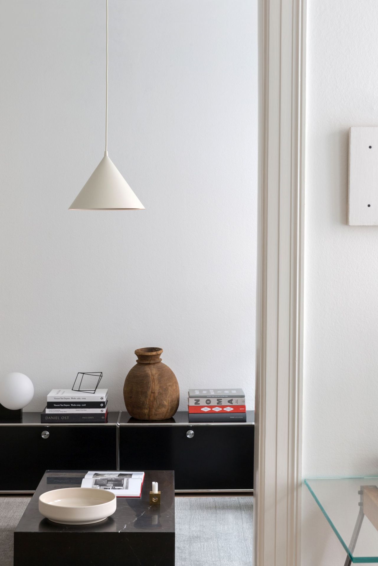 Annular Pendelleuchte von Woud, eine moderne Hängelampe in Weiß, die über einem Wohnzimmer-Setup hängt.