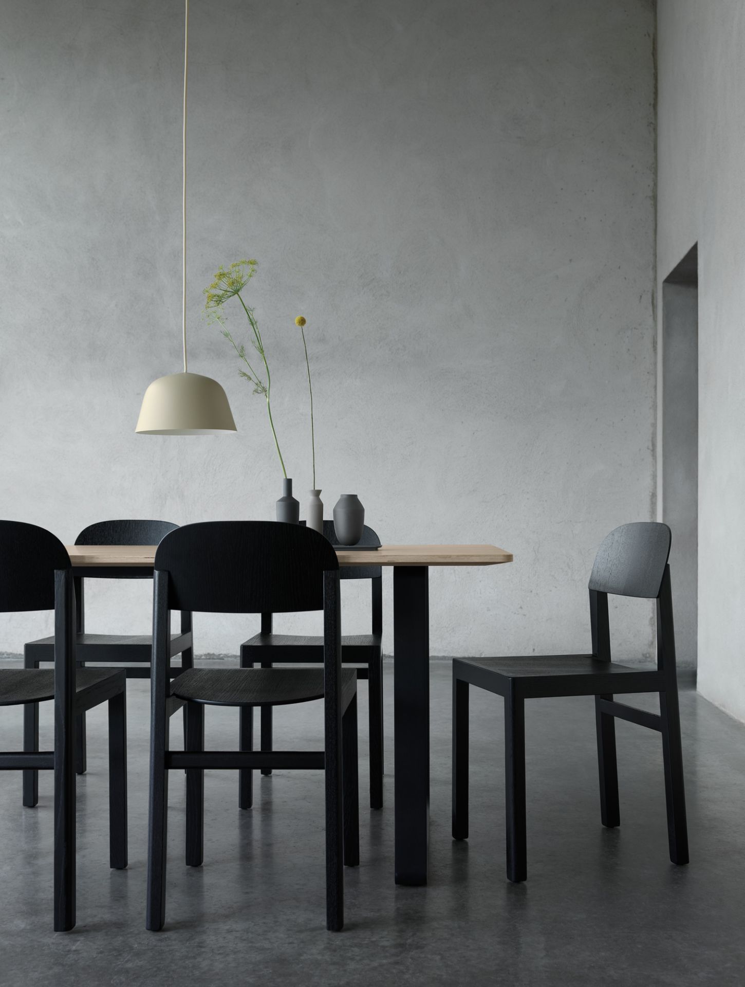 Muuto 70/70 Table Esstisch mit schwarzen Stühlen und minimalistischer Pendelleuchte in modernem Esszimmer.