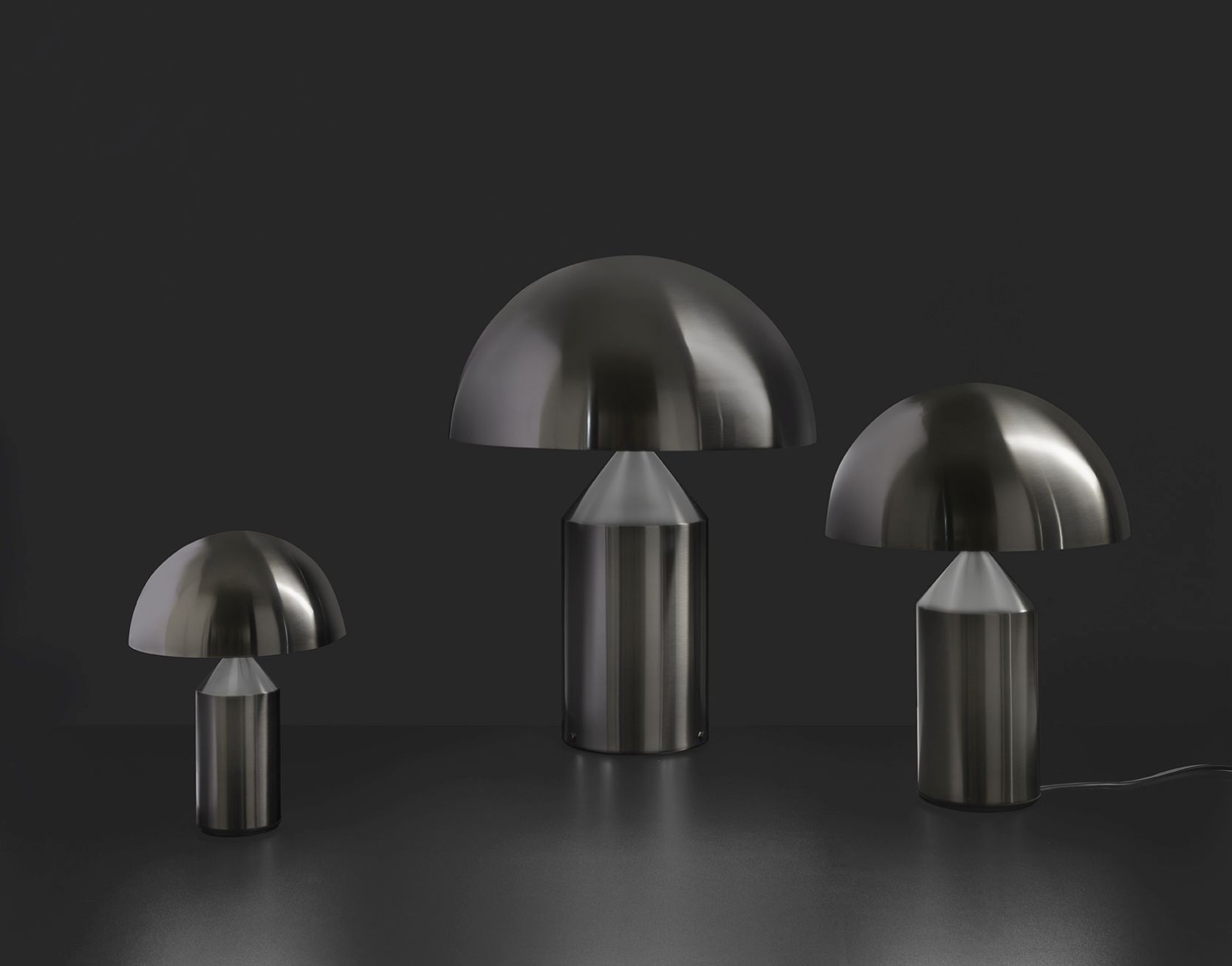 Drei Atollo Tischleuchten von Oluce in Nickel auf dunklem Hintergrund, modernes Design.