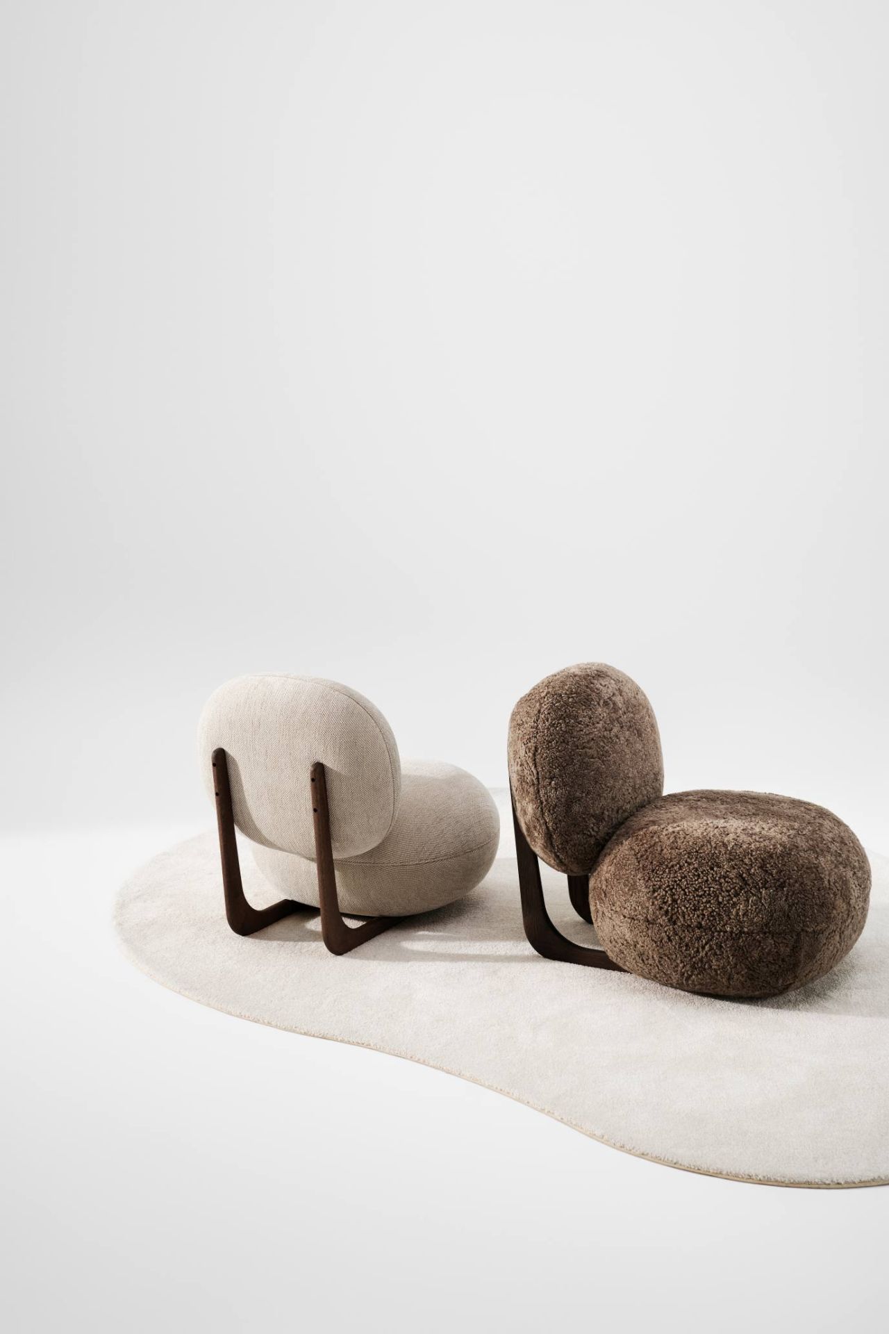 NORR11 Copper Lounge Sessel mit Holzgestell in Beige und Braun auf Teppich.
