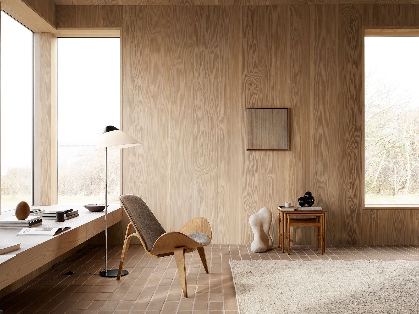 Helle Inneneinrichtung mit Carl Hansen & Søn Opala Stehleuchte, Sessel und minimalistischer Dekoration.