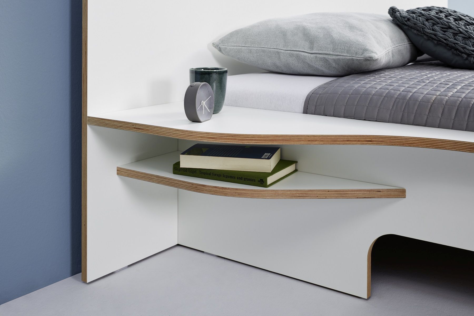 Detailaufnahme vom weißen Plane Doppelbett von Müller Möbelwerkstätten mit Ablagefächern und Bettwäsche.