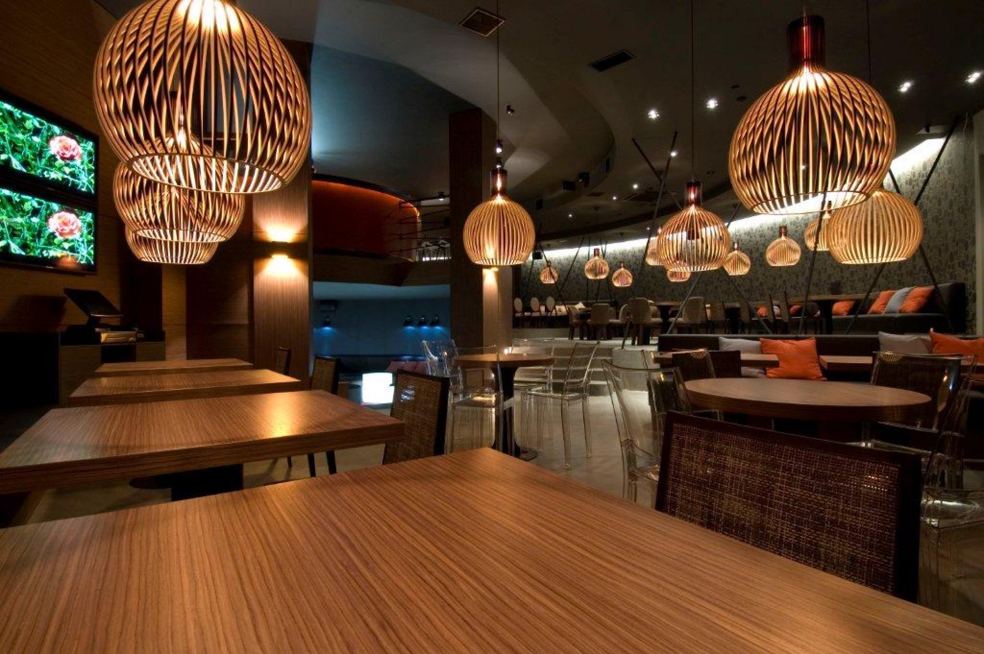 Innenaufnahme eines Restaurants mit mehreren Octo Pendelleuchten von Secto Design aus Holz über Tischen.