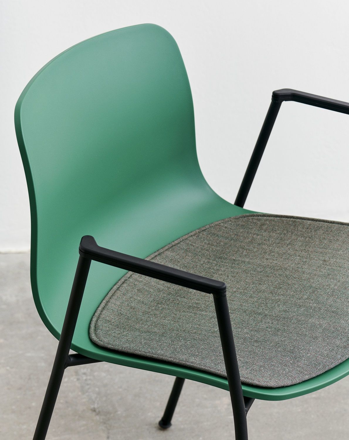 Grüner Hay About A Chair Stuhl mit grauem Seat Pad Sitzkissen für mehr Komfort.