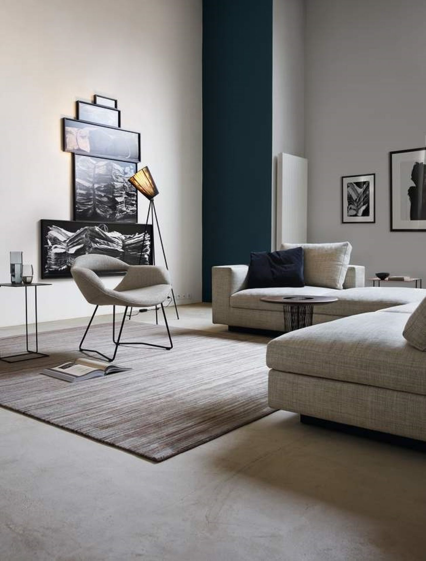 Moderner Wohnraum mit Walter Knoll Beistelltisch, grauem Sofa, Sessel und minimalistischer Dekoration.