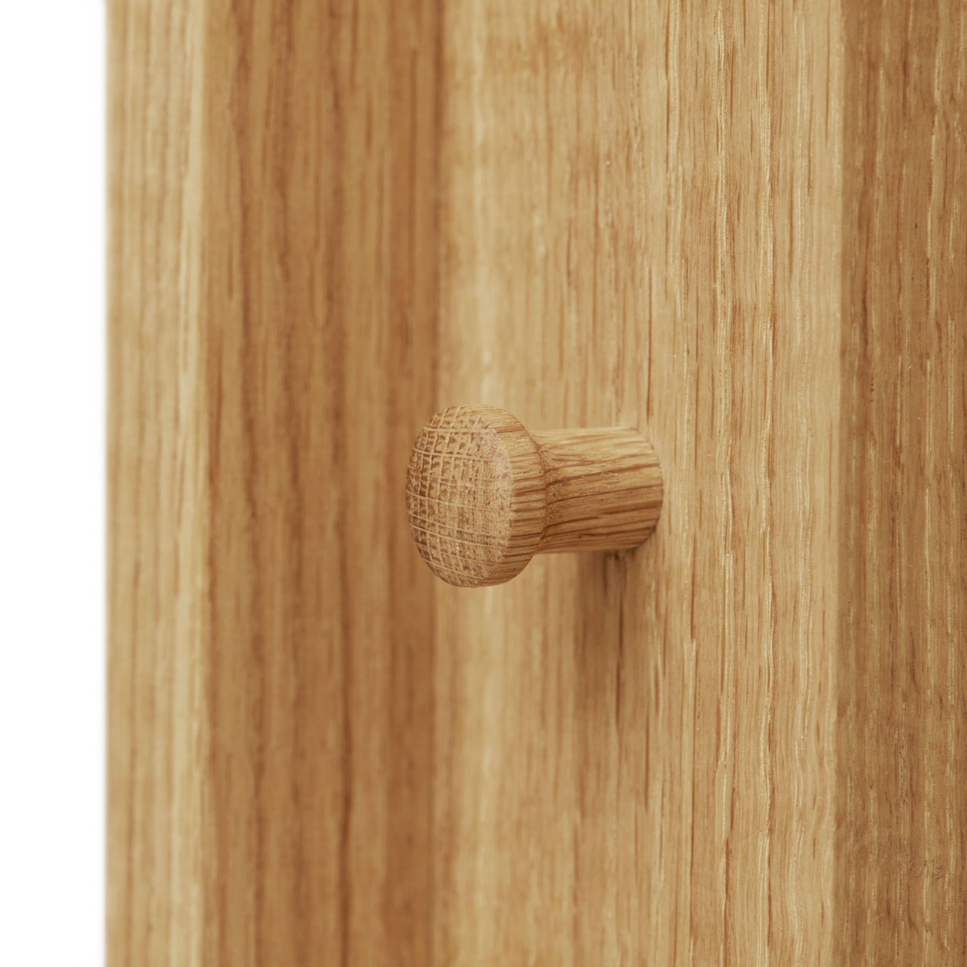 Detailaufnahme des Form & Refine Foyer Garderobenständers aus Eiche mit Holzhaken.