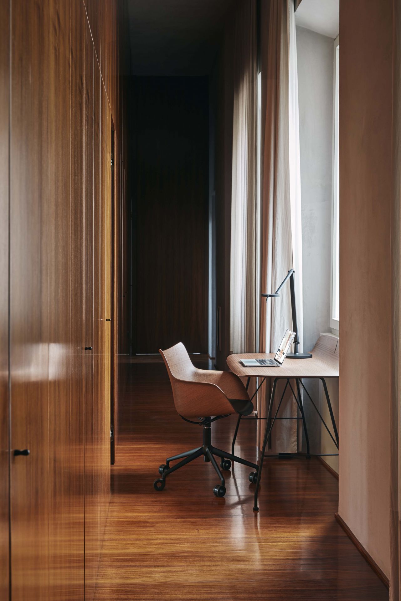 Q/Wood Drehstuhl mit dunklem Holz und verchromtem Gestell in einem modernen Büro.