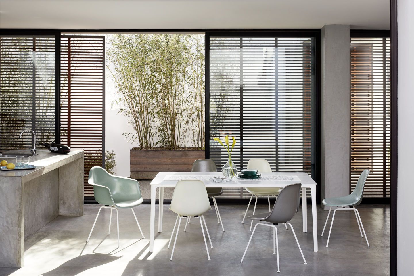 Esszimmer mit Esstisch und mehreren Eames Fiberglass Stühlen DSX von Vitra in verschiedenen Farben.