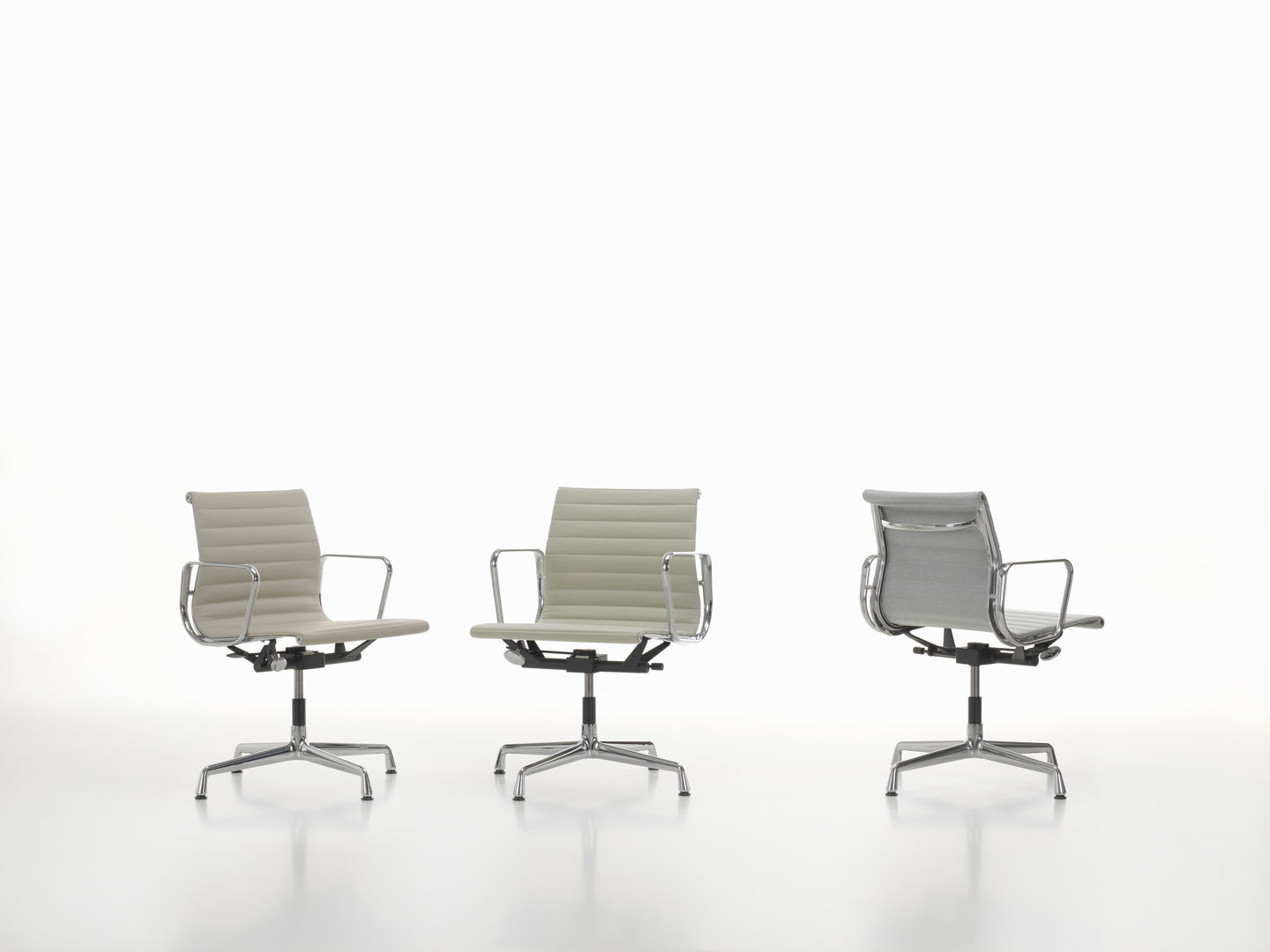 Drei Vitra Aluminium Chairs EA 131 in verschiedenen Ansichten und Farben auf weißem Hintergrund.
