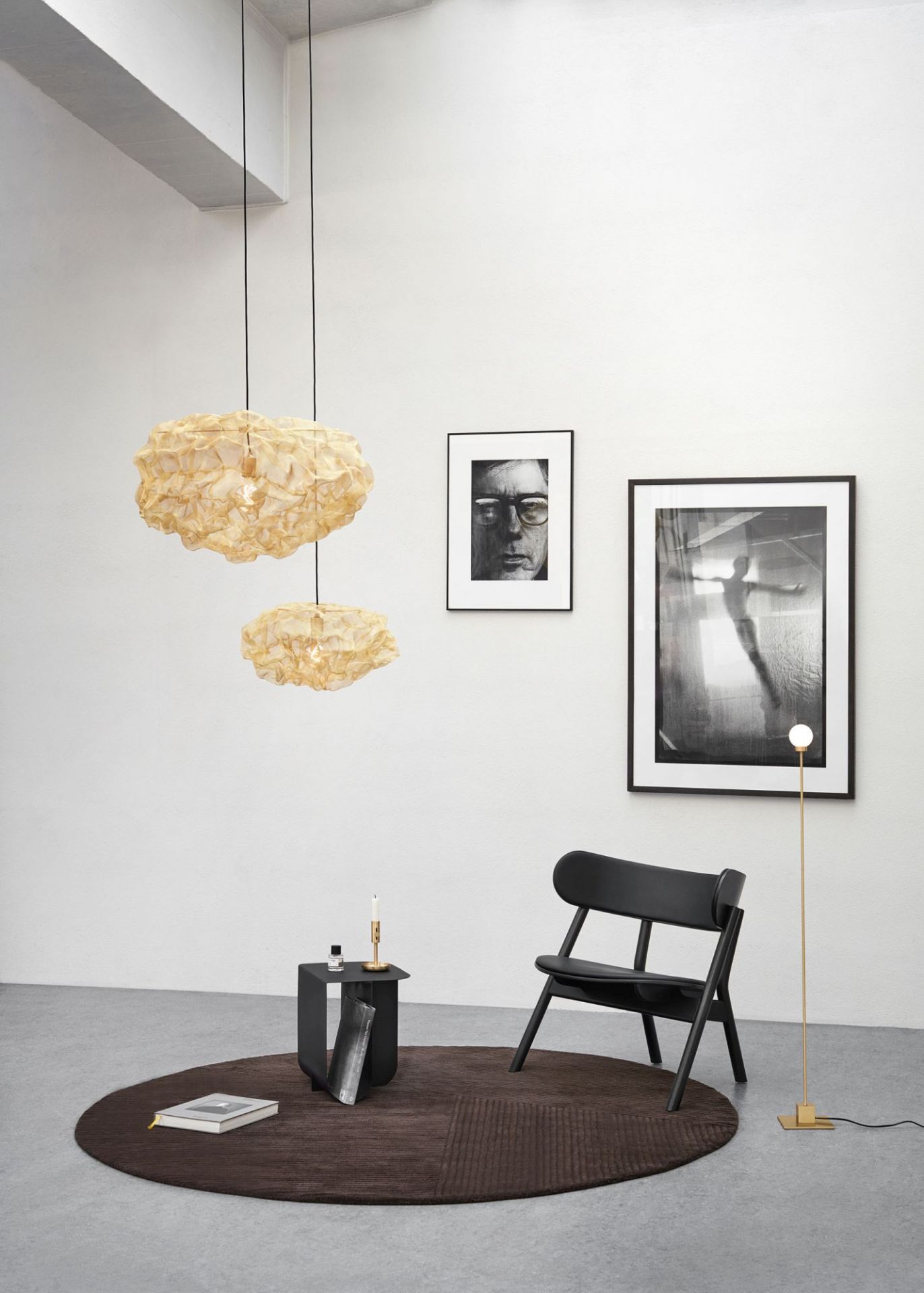 Schwarzer Oaki Lounge Chair mit Polster, minimalistisches Design, auf braunem Teppich in modernem Wohnzimmer.