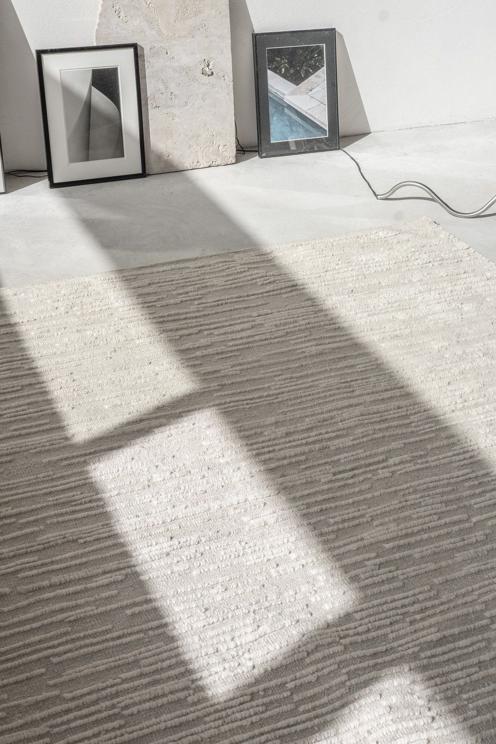 Detailaufnahme des Nanimarquina Doblecara Rug Teppichs in Beige mit horizontalem Streifenmuster und Schatten.