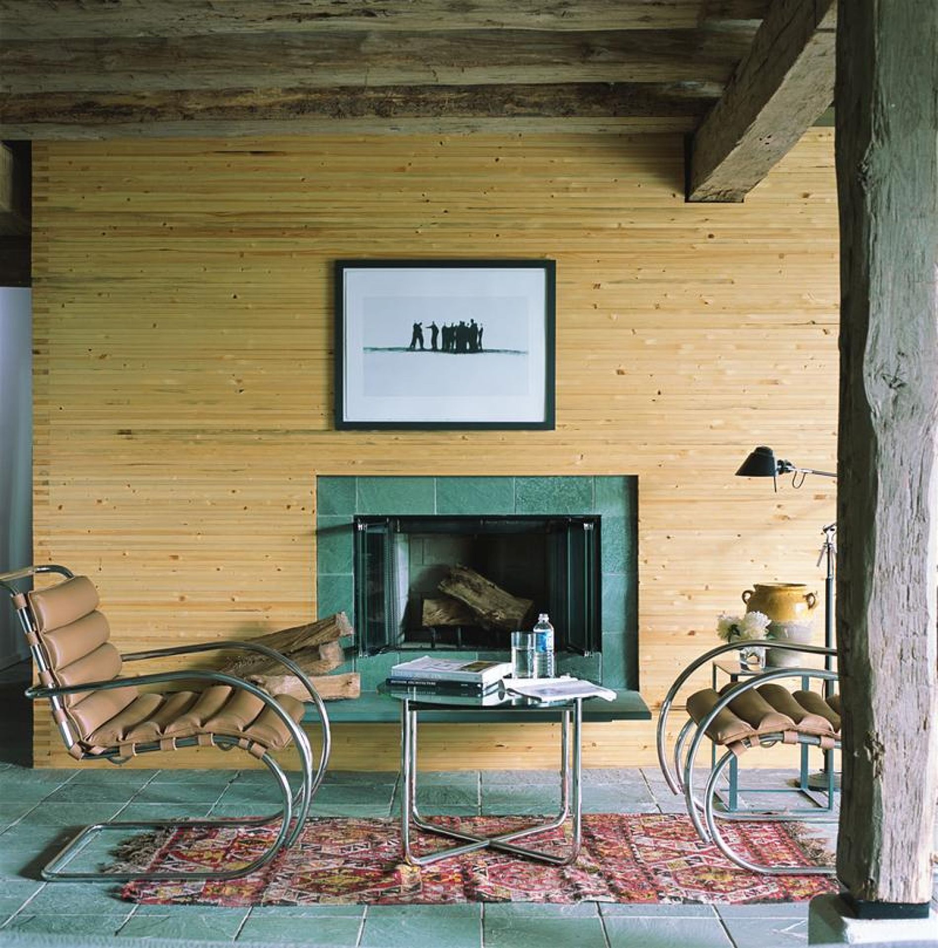MR Couchtisch von Knoll International vor Kamin mit Sessel und Teppich im Wohnzimmer.