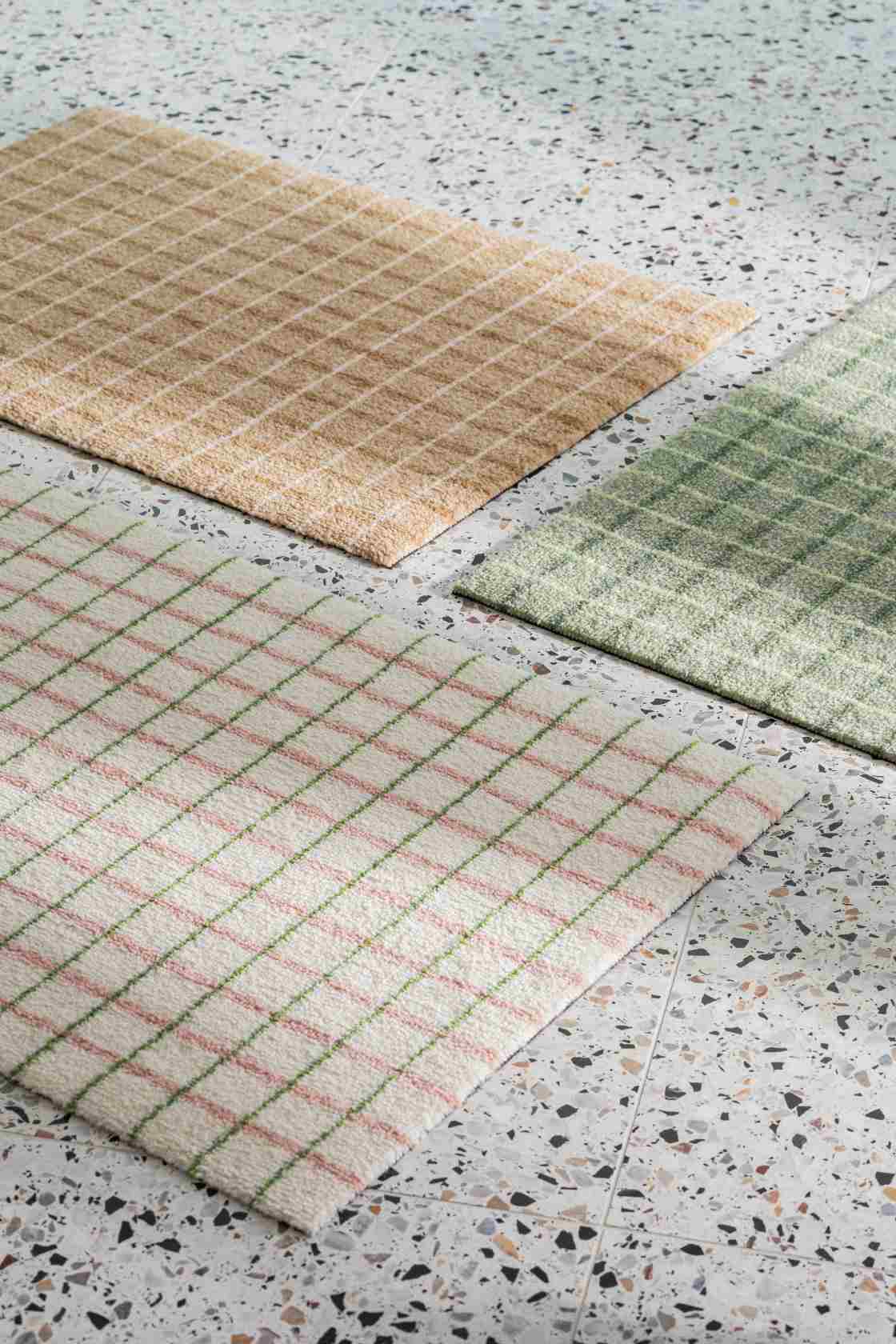 Nahaufnahme von drei Grid Heymat Fußmatten mit Karomuster in Beige, Grün und Lime Candycane.