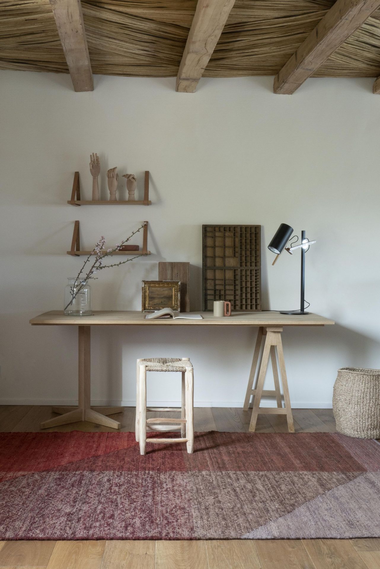 Capas Teppich von Nanimarquina in einem Arbeitszimmer mit Holzboden und rustikalen Möbeln.