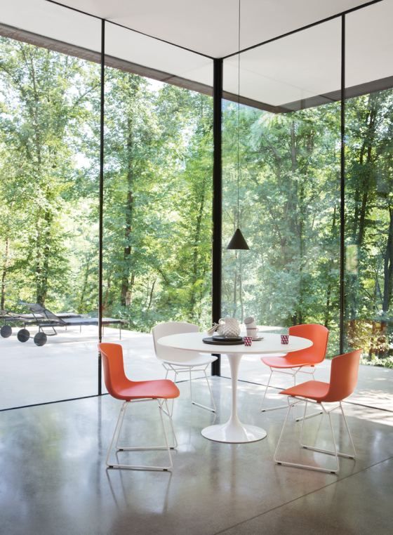 Esszimmer mit Bertoia Plastic Side Chairs von Knoll International in Orange und Weiß.