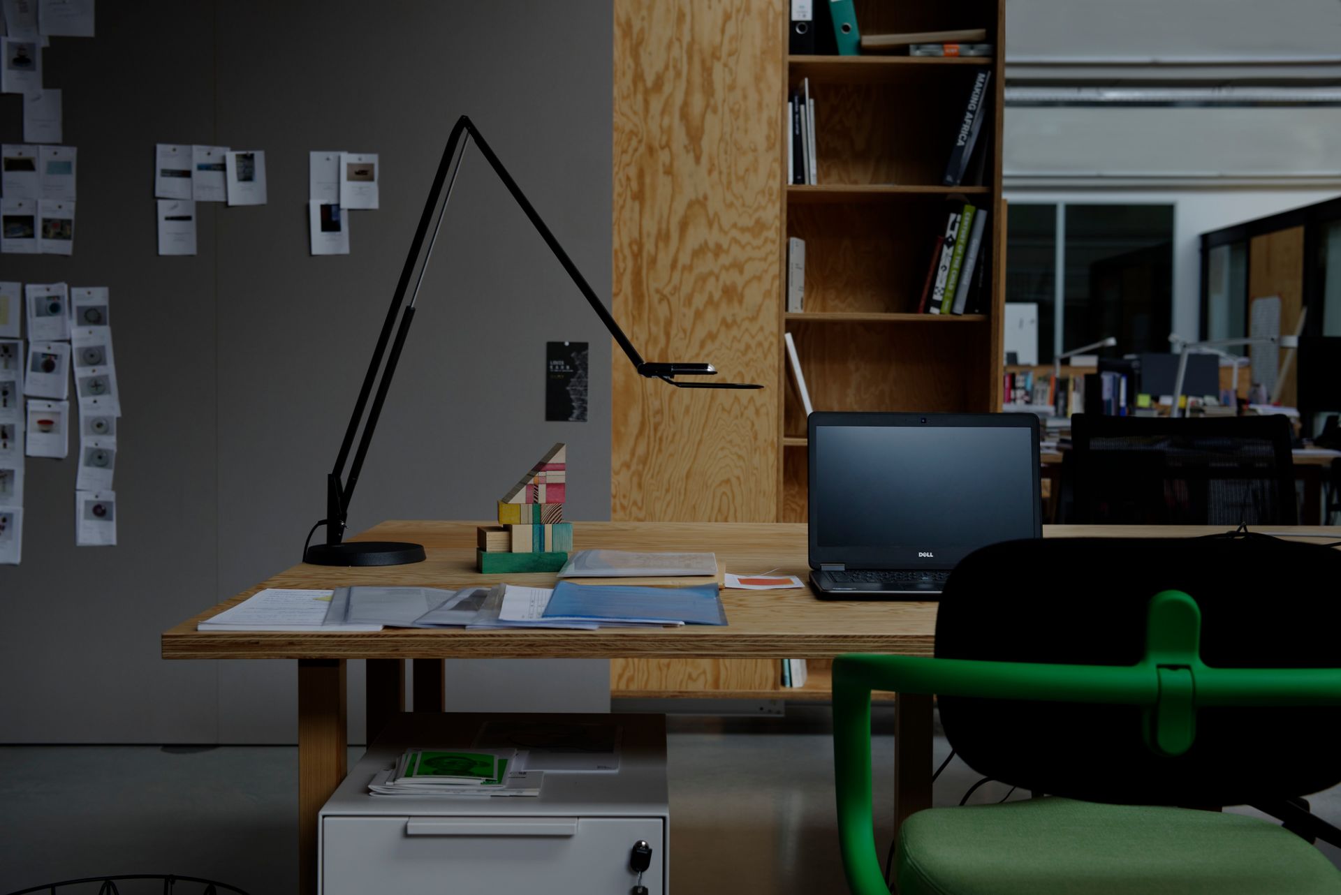 Liftolino LED Tischleuchte in Schwarz von Belux auf einem Schreibtisch im Büro.