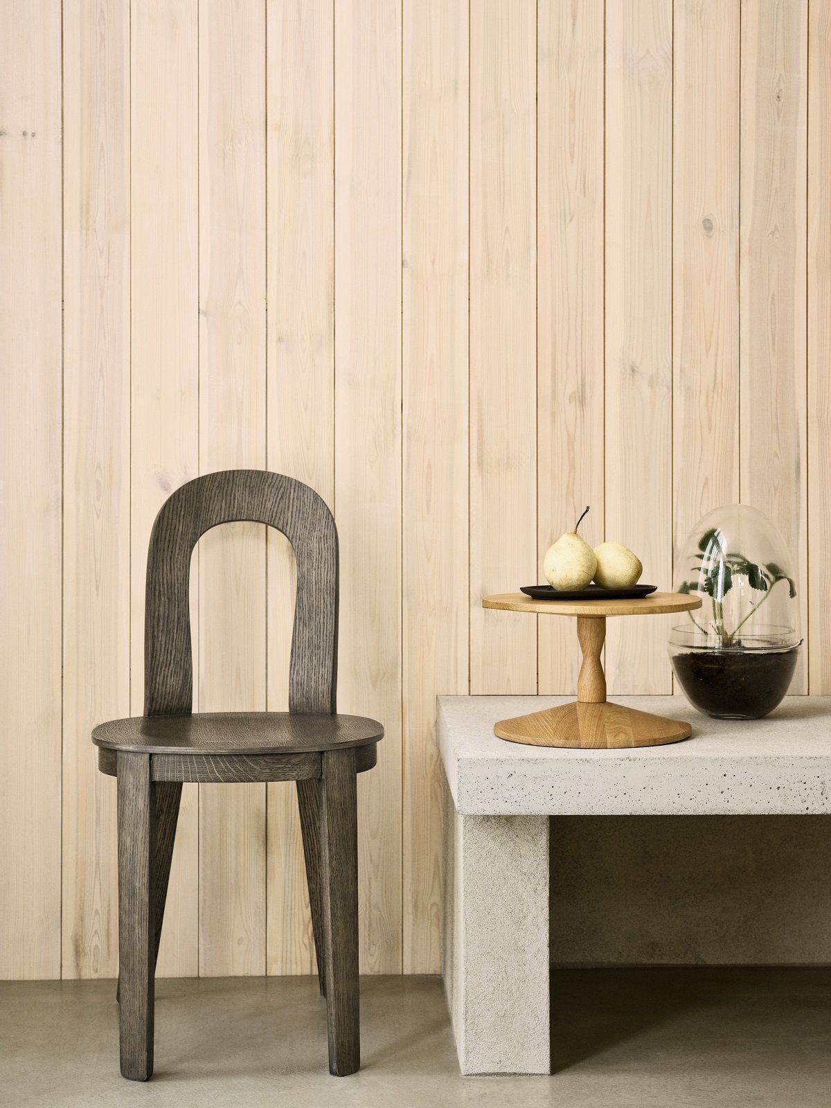 Olivia Chair von Design House Stockholm, Holzstuhl in Grau vor einer Holzwand.