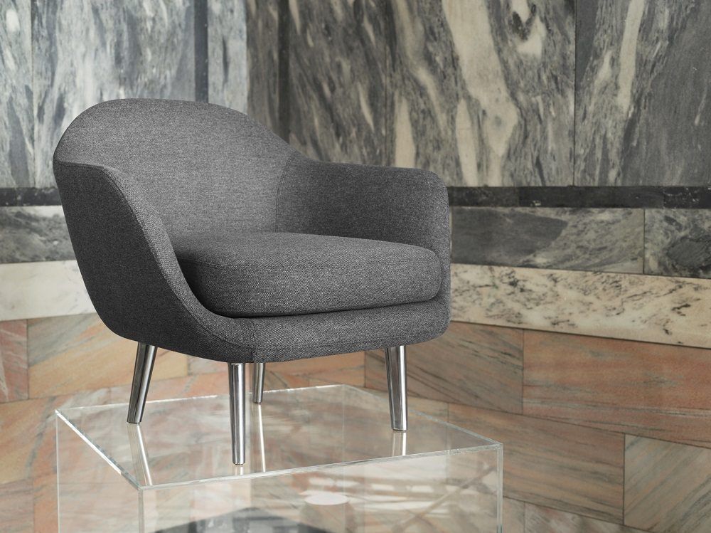 Grauer Sum Lounge Armchair Sessel von Normann Copenhagen mit Stahlbeinen auf transparentem Tisch.