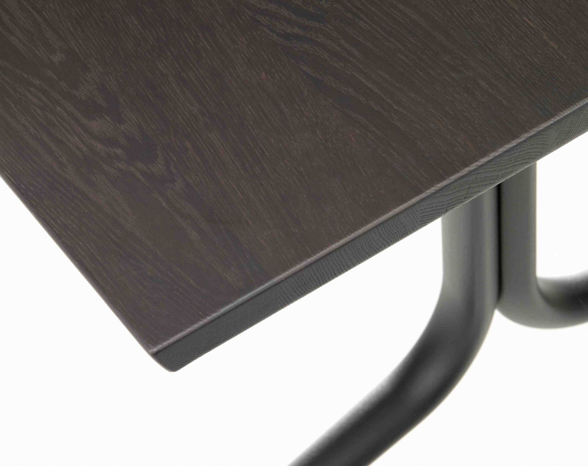 Detailaufnahme der dunklen Holzplatte und des schwarzen Stahlgestells vom Vitra Belleville Table Tisch.
