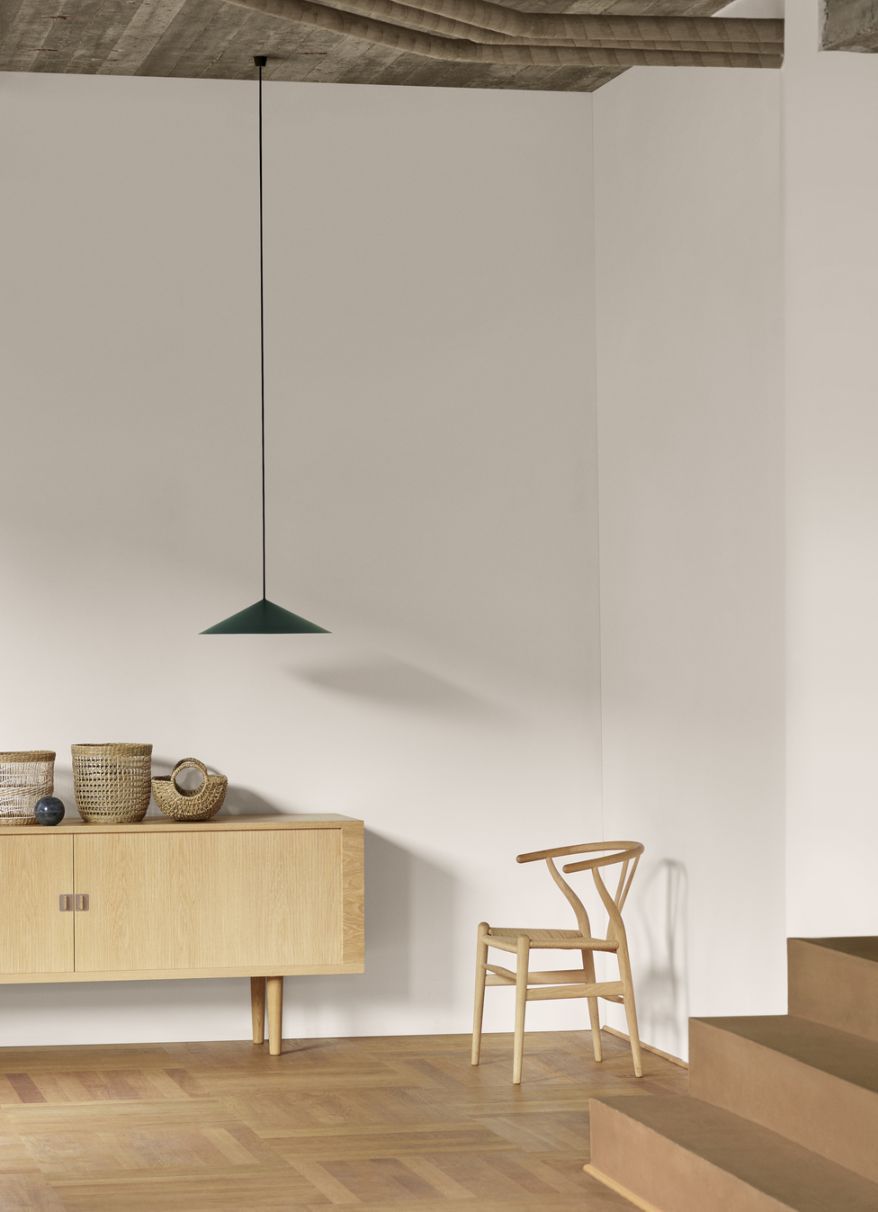 Grüne BT1001 Pendelleuchte von Carl Hansen & Søn über Sideboard mit Flechtkörben im Interieur.