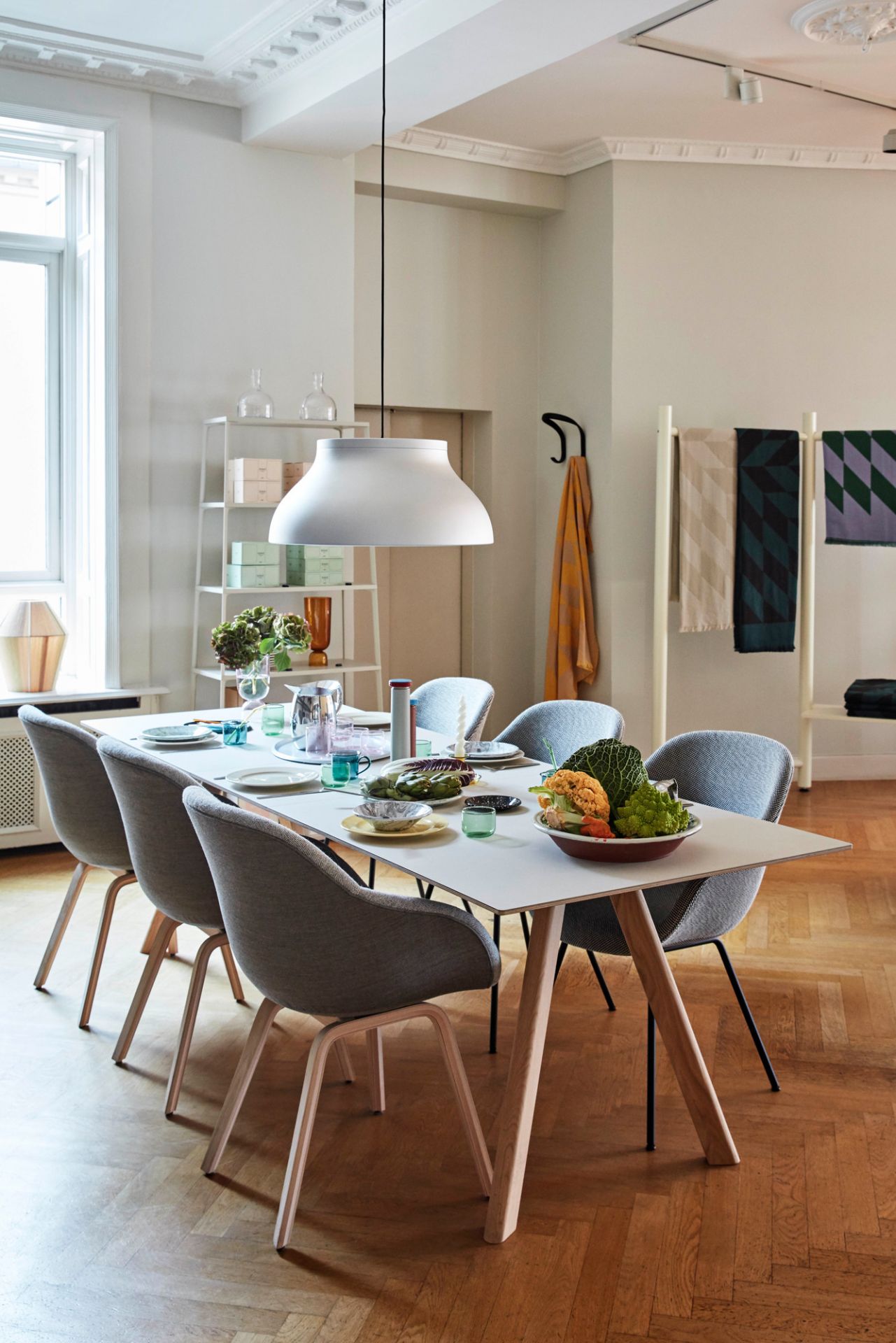 Esstisch mit sechs grauen Hay About a Chair AAC123 Stühlen mit Holzbeinen in einem hellen Esszimmer.