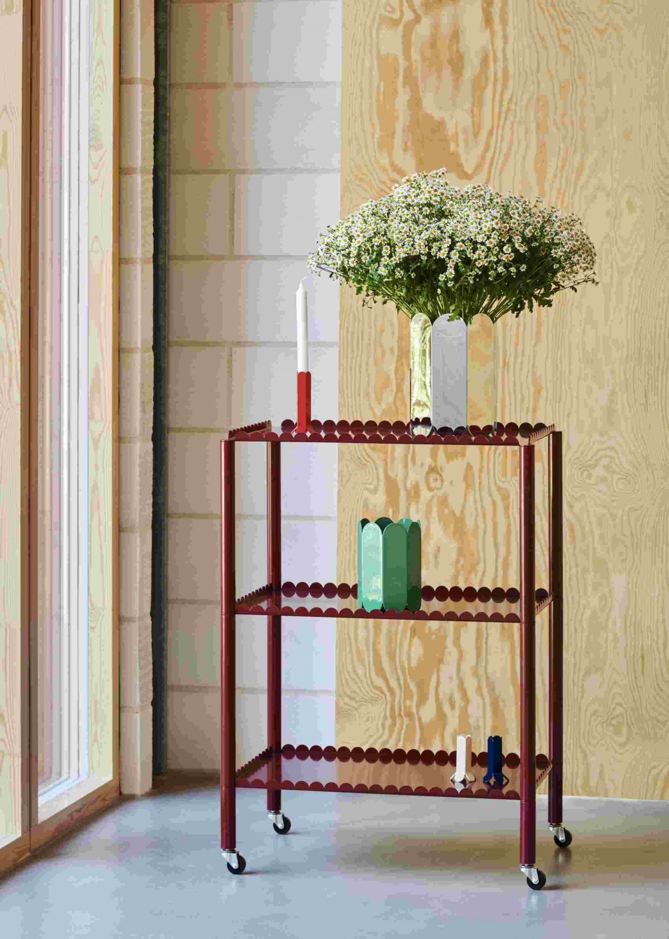 Hay Arcs Vase Mirror auf rotem Servierwagen mit Blumenstrauß und Kerze, modernes Wohndesign.