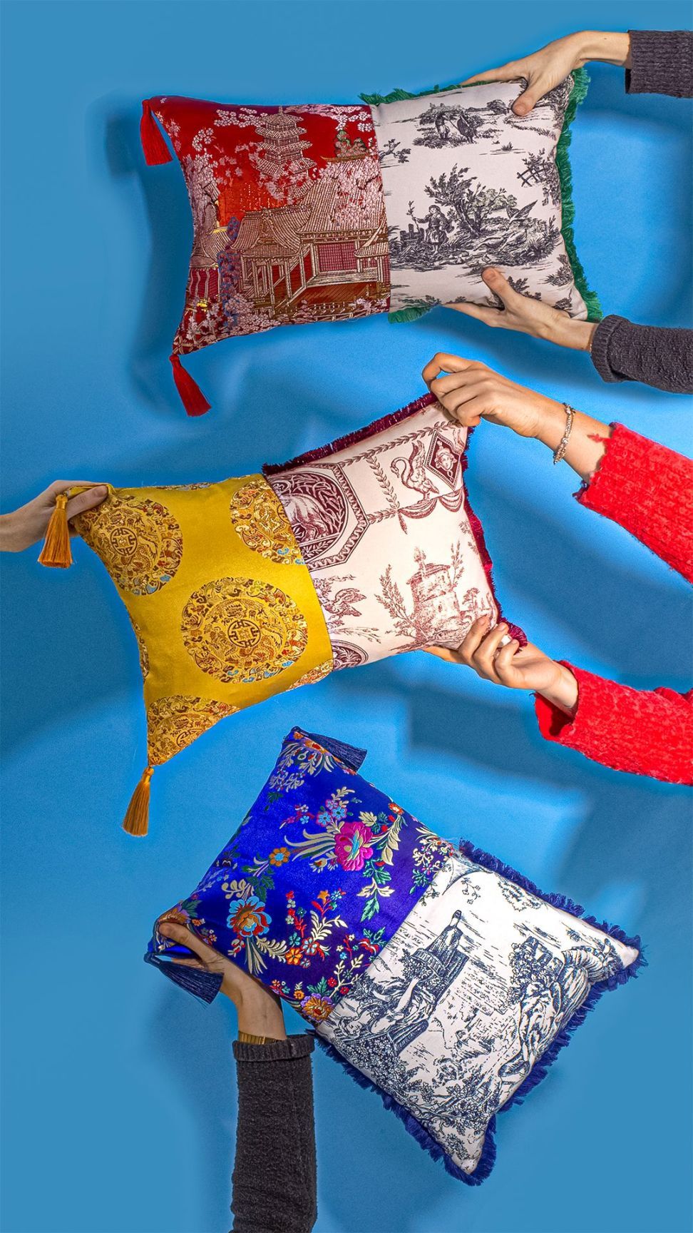 Drei Hybrid Pillows Kissen von Seletti mit unterschiedlichen Mustern und Farben werden von Händen gehalten.