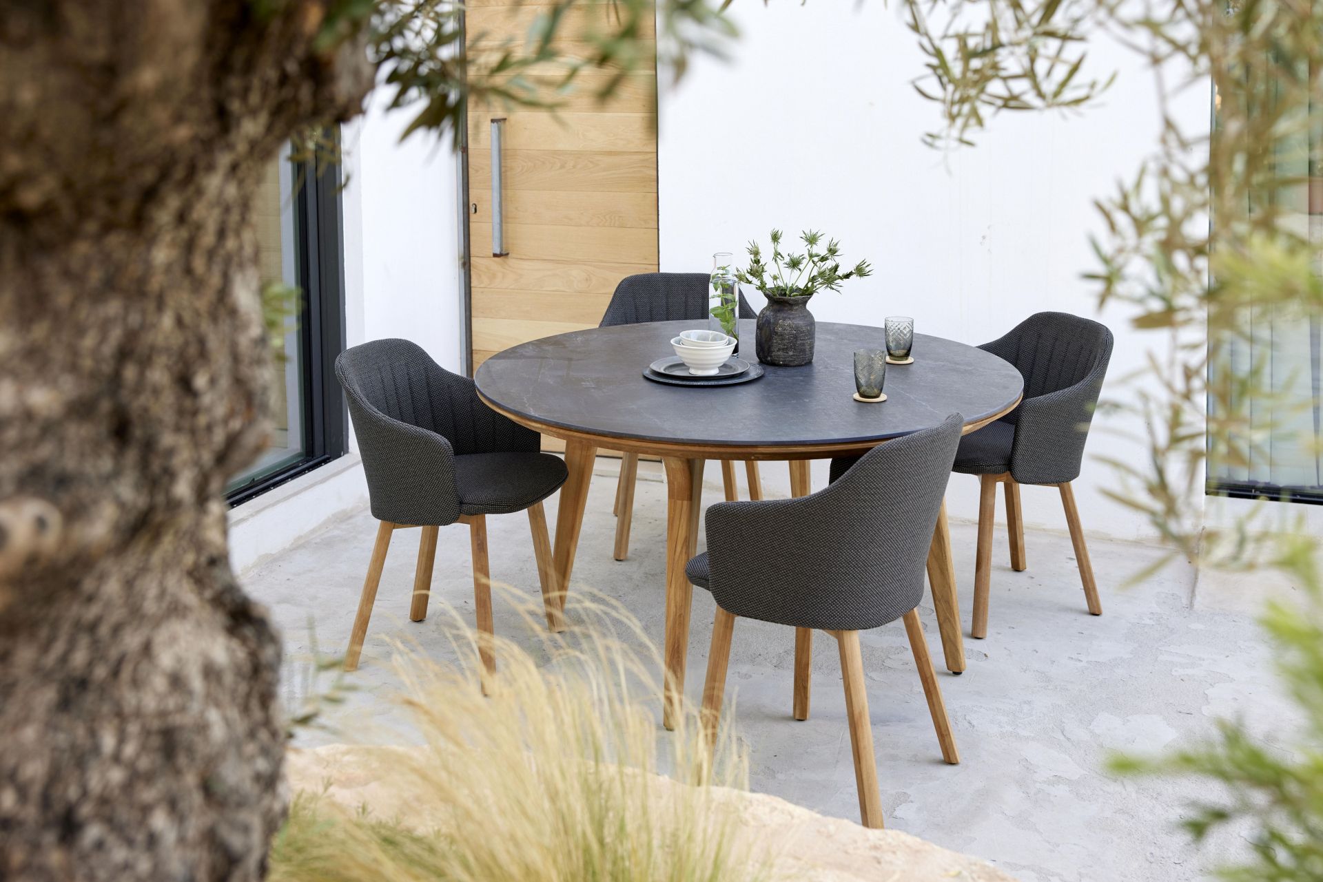 Bild eines Cane-Line Choice Outdoor Stuhls mit Teakgestell und schwarzem Cane-Line Geflecht.