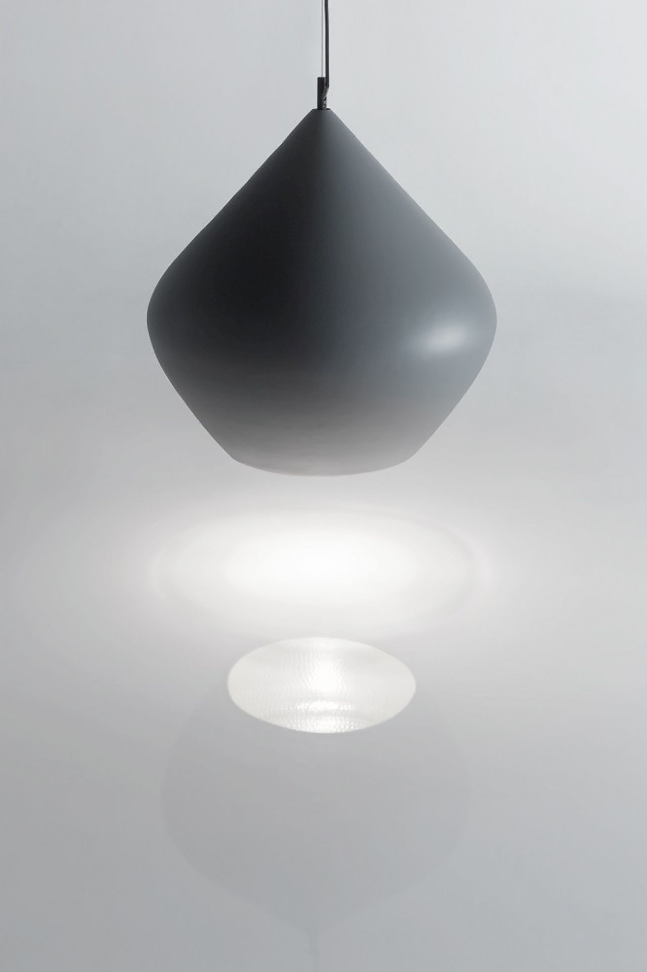 Graue Tom Dixon Pendelleuchte Beat Stout mit Lichtschein und Schattenwurf.