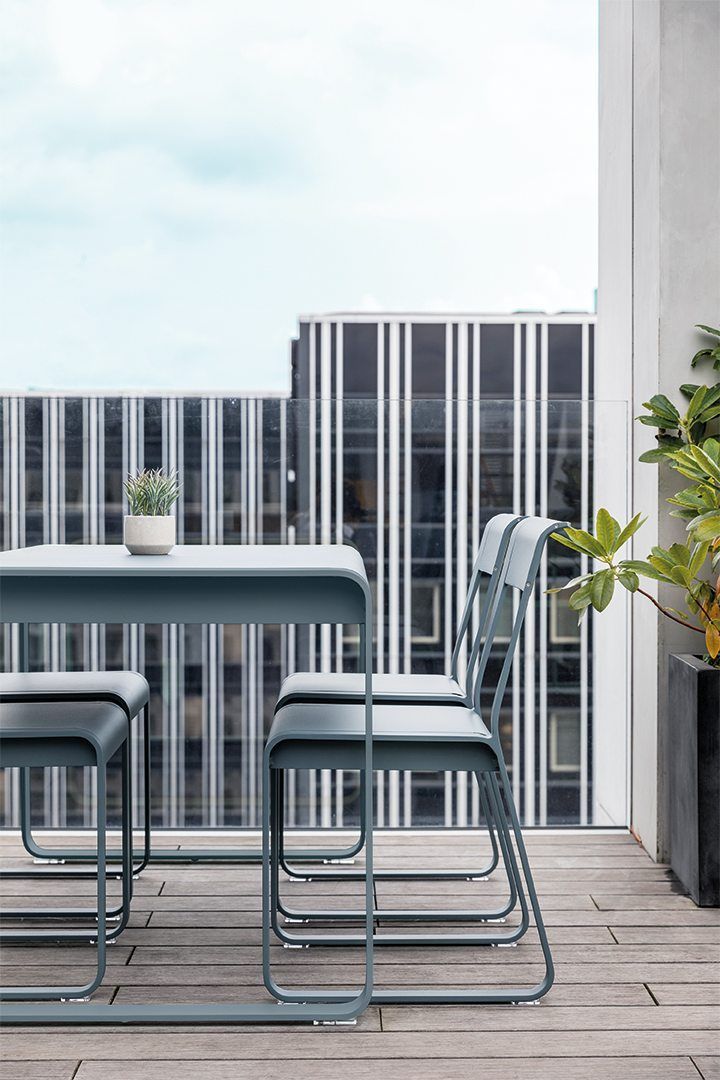 Bellevie Stuhl Muskat von Fermob Outdoor auf einer Terrasse mit Tisch und Pflanze.