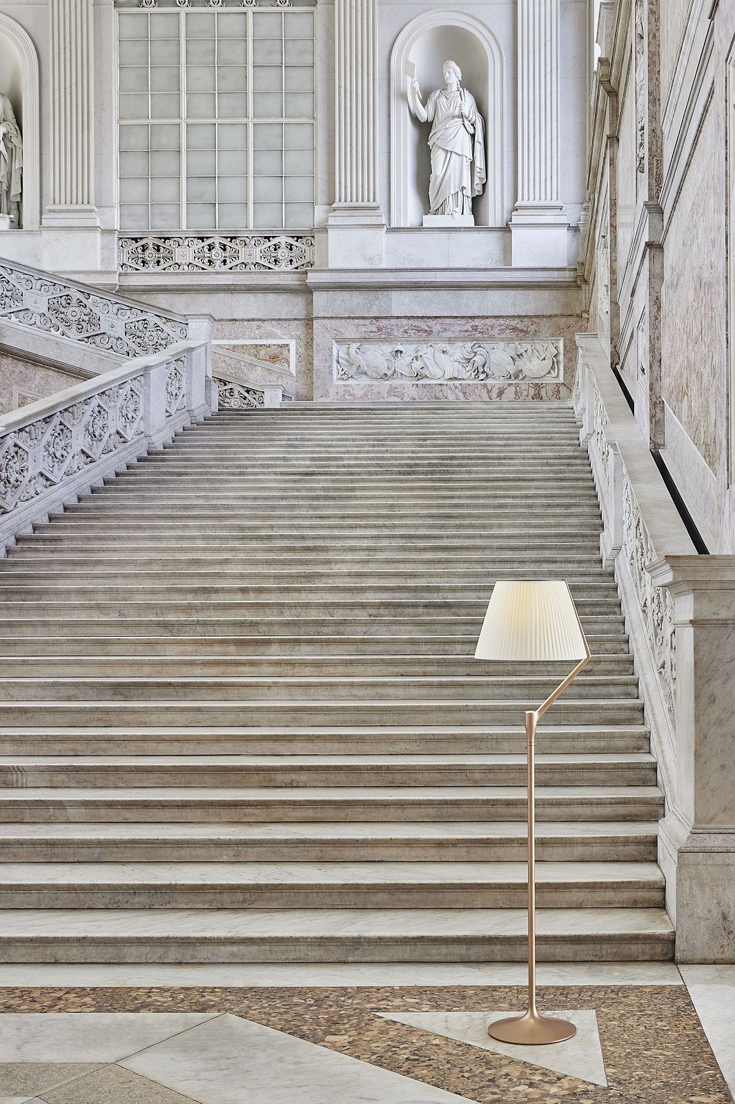Angelo Stone Stehleuchte von Kartell vor einer monumentalen Treppe mit Marmorstufen und Skulpturen.