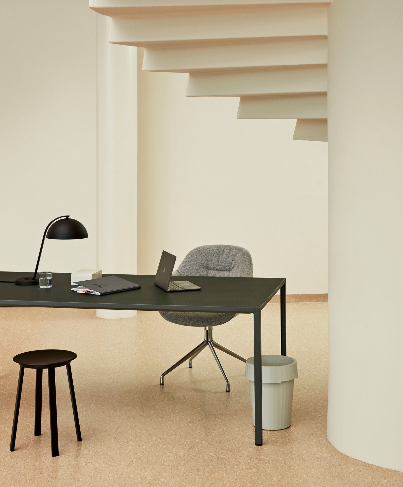Moderner Arbeitsplatz mit Hay About a Chair AAC 121 Soft Duo Stuhl in Grau und schwarzem Schreibtisch.