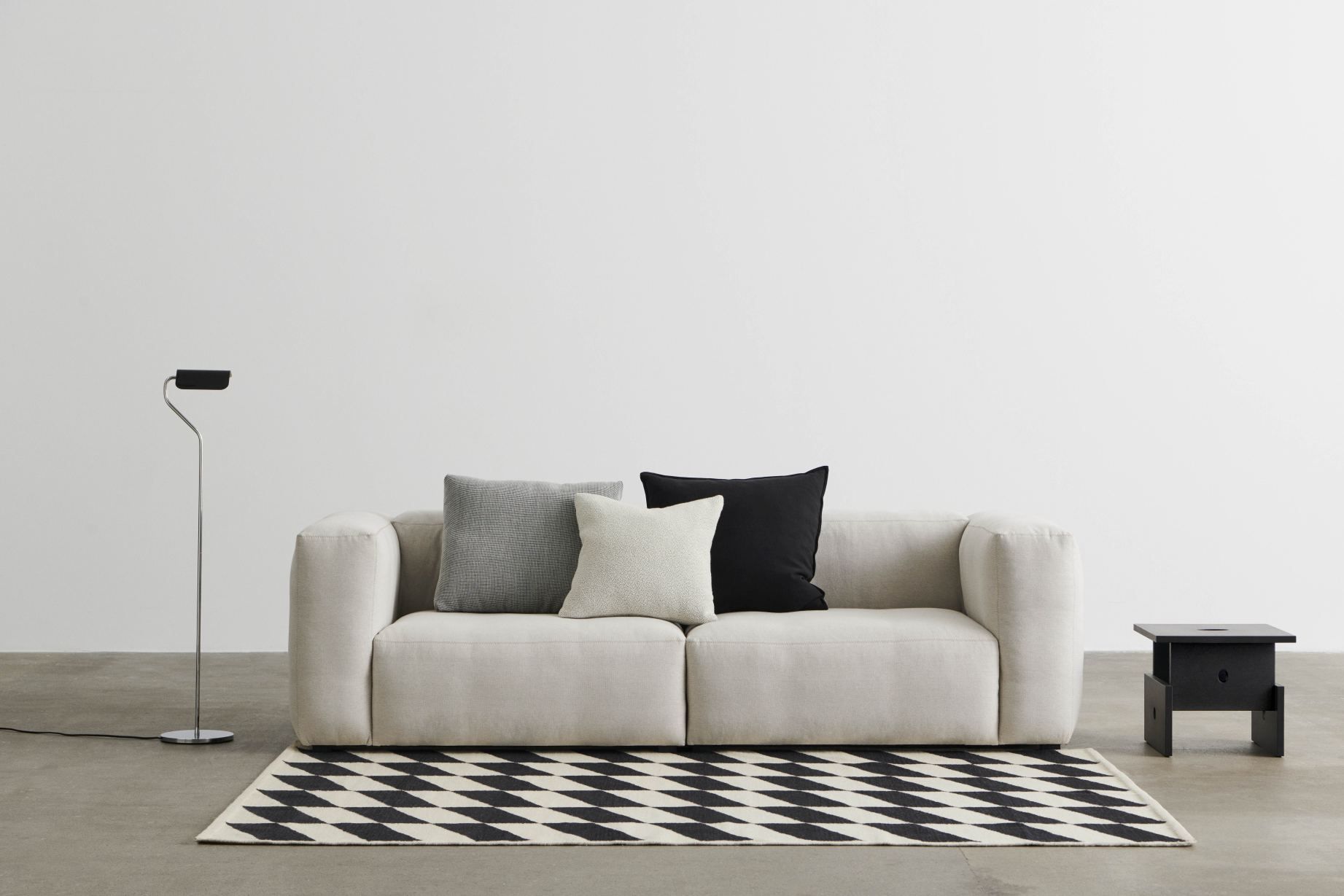 Mags Soft Sofa mit Kissen auf Teppich, modernes Wohnzimmer-Interieur mit Design Lampe und Beistelltisch.