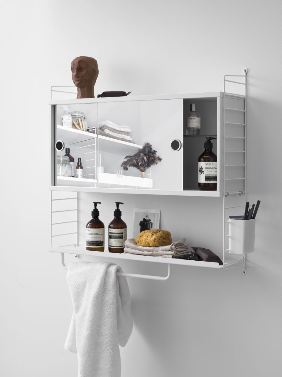 Schwarze String Furniture Stangen für Metallregal (78 cm) an einer weißen Wand, mit Badutensilien dekoriert.