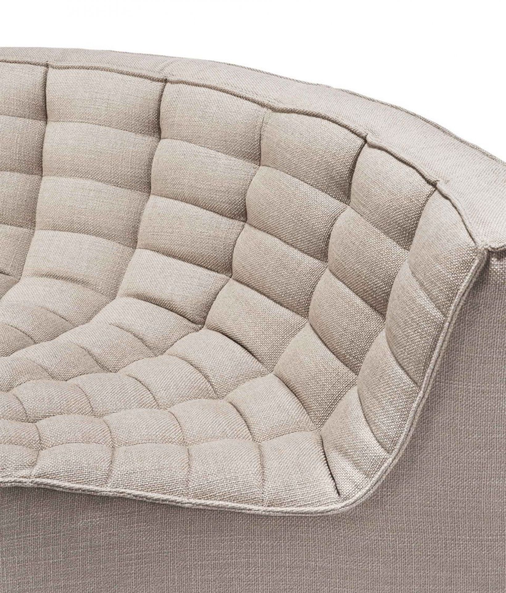 Detailaufnahme des N701 Sofas von Ethnicraft: Runde Ecke mit gesteppter, beiger Polsterung.