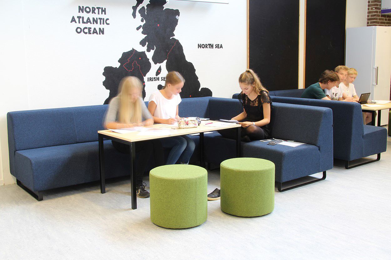 Grüne point POP R 450 Pouf Sitzhocker auf Rollen im modernen Büro mit blauen Sitzbänken.