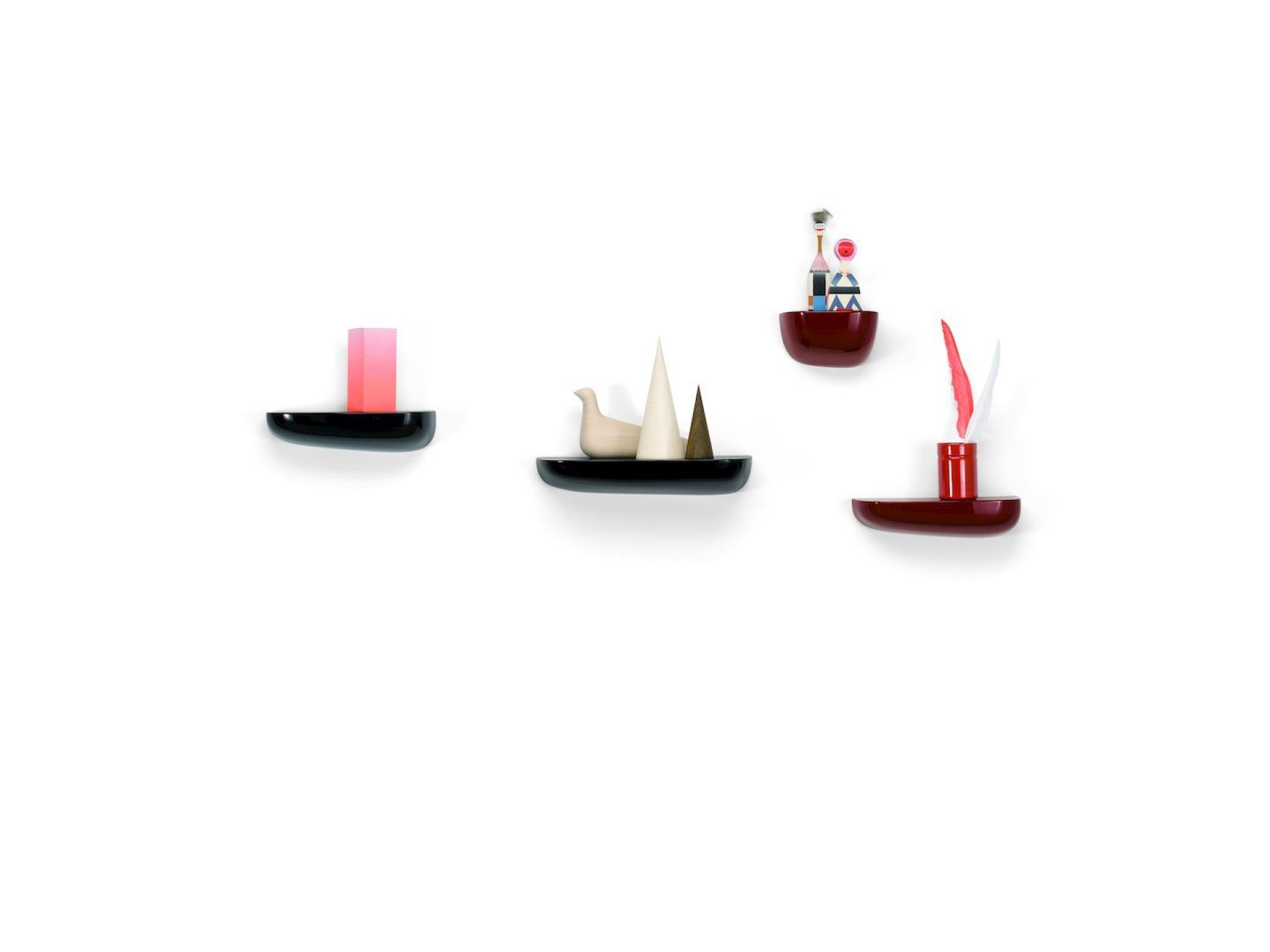 Vitra Corniches Wandboards in Schwarz und Rot an einer weißen Wand mit Deko-Objekten.