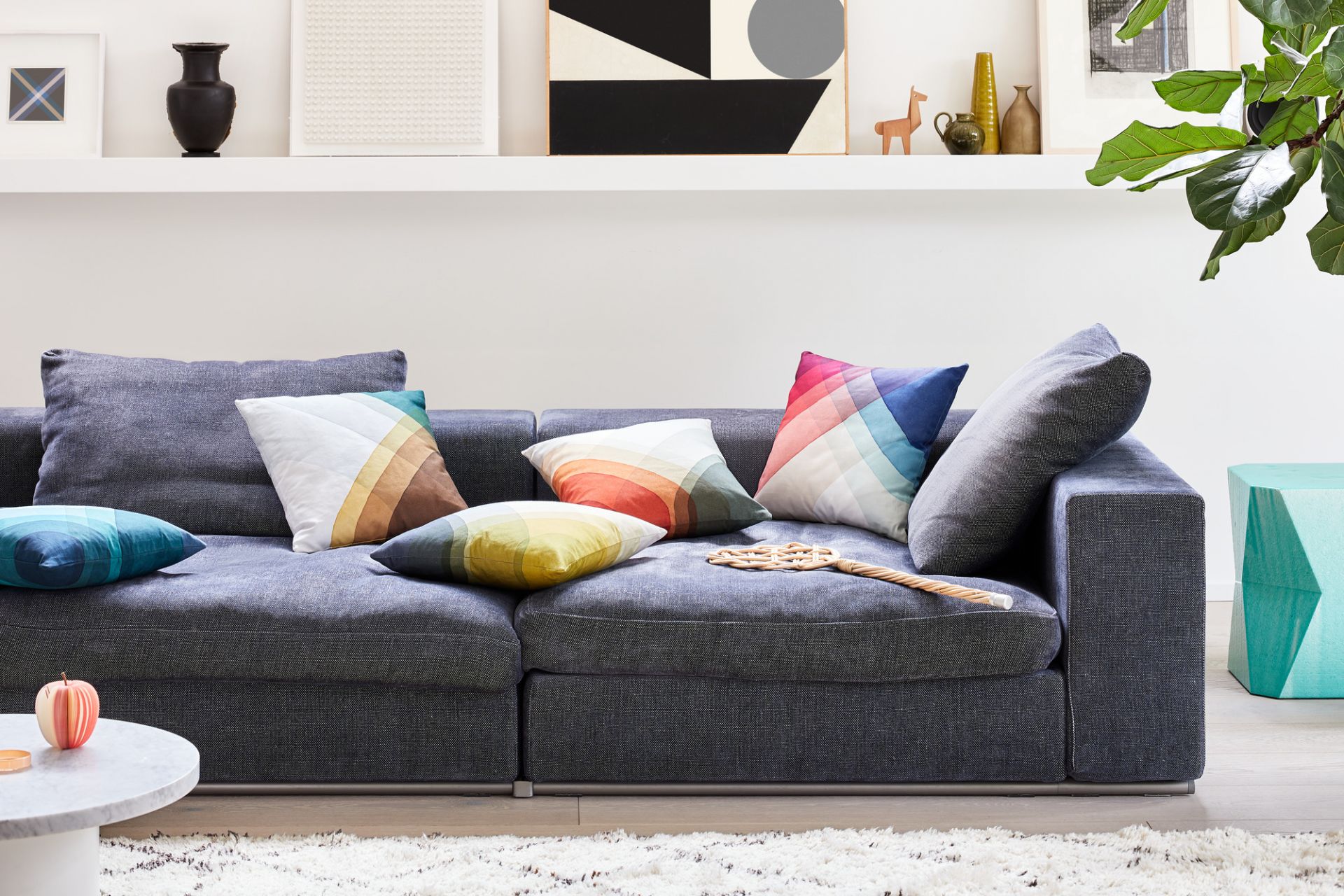 Graues Sofa mit bunten Heringbone Pillows Kissen von Vitra im Wohnzimmer mit Deko.