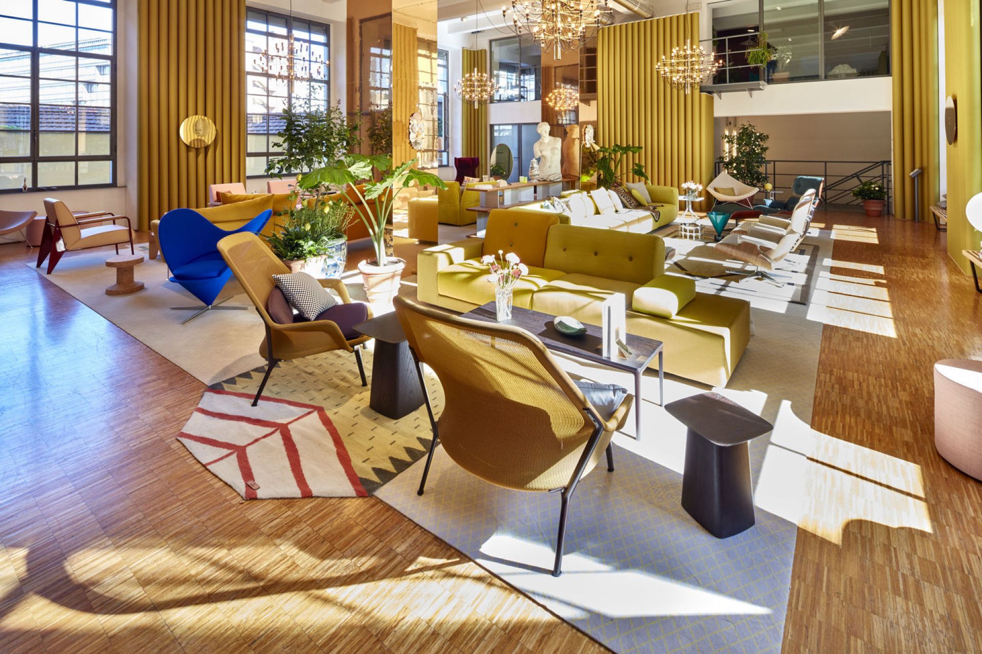 Innenaufnahme eines modernen Büros mit gelben Sofas und einem blauen Heart Cone Chair von Vitra.