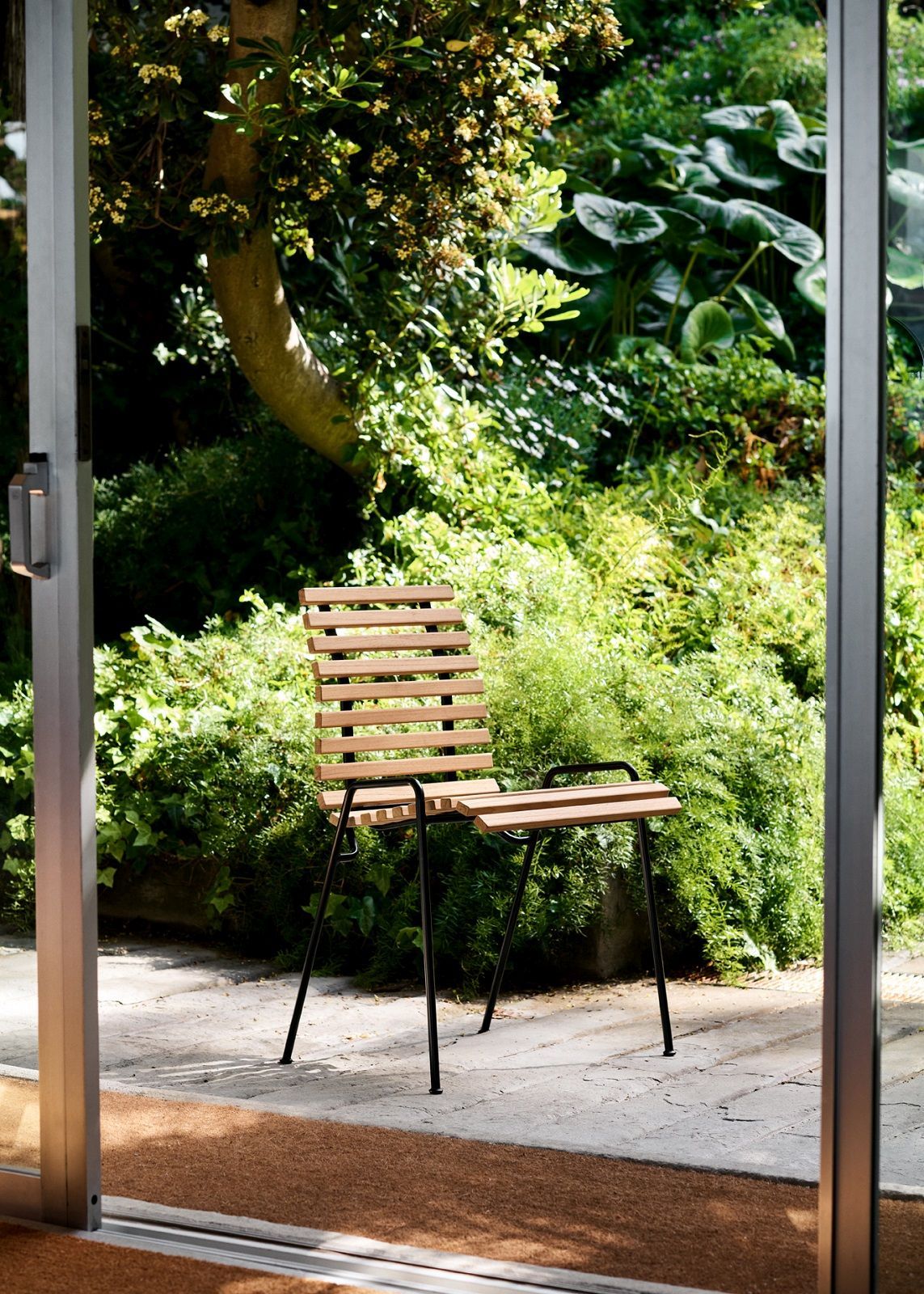 RFH Robin Day RD4 Esszimmerstuhl von AndTradition aus Holz und Metall im Garten.