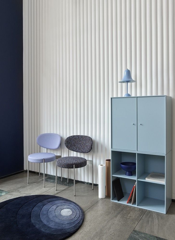 Pantop Tischleuchte in Hellblau auf einem blauen Schrank, stilvolles Interieur mit Stühlen und Teppich.