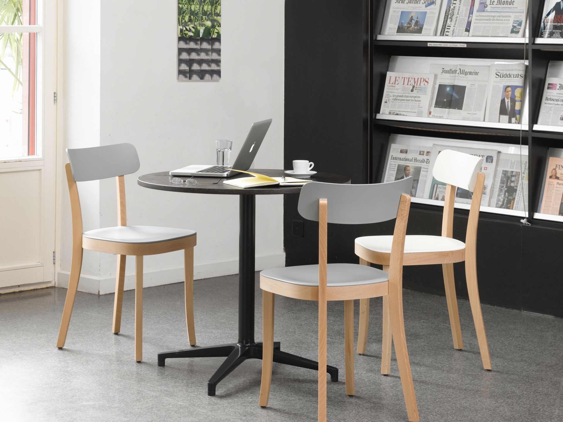 Vitra Bistro Table mit runder Tischplatte und Stühlen in einem modernen Café oder Büro.