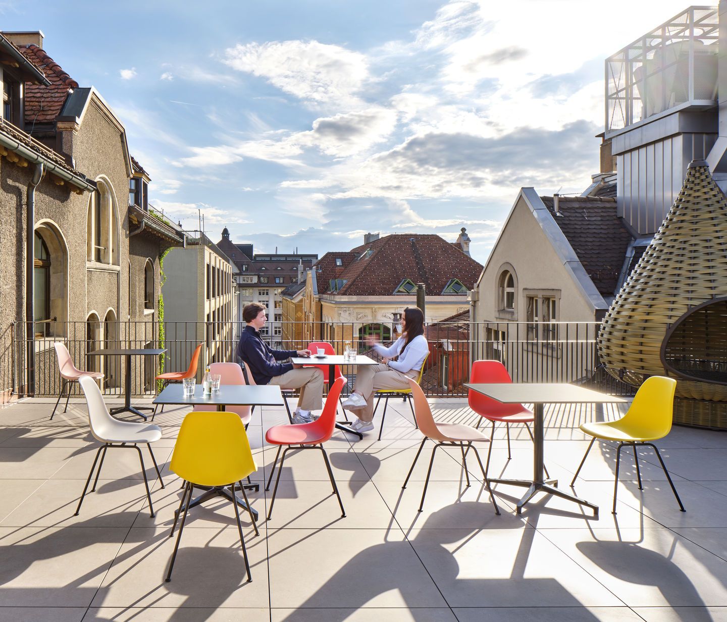 Eames Fiberglass Chair DSX Stühle von Vitra auf einer Dachterrasse mit zwei Personen.