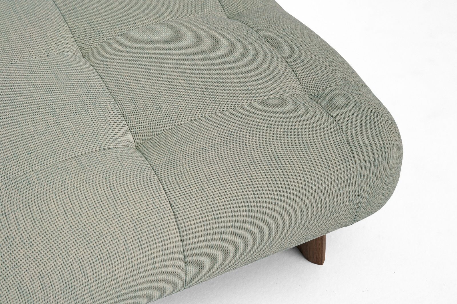 Nahaufnahme des Quilton Hockers von Hay in hellblau mit Knopfheftung und Holzfuß.