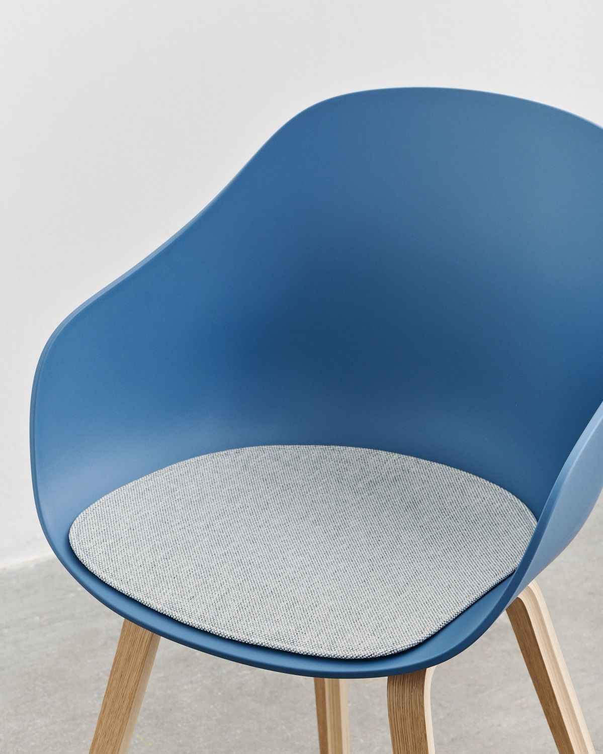 Blauer About a Chair (AAC 222) Stuhl von Hay mit grauem Sitzkissen und Holzbeinen.