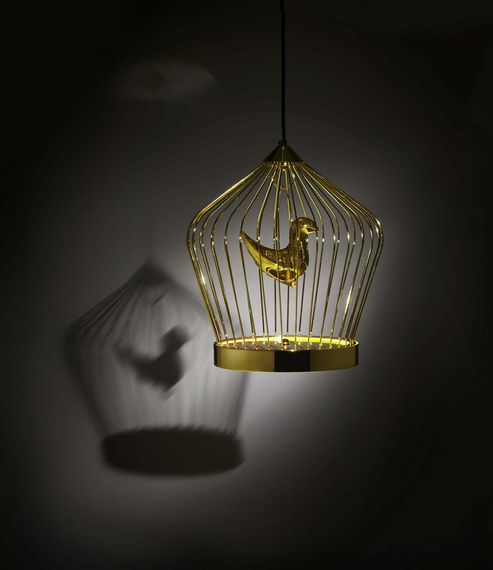 Goldene Twee T. Hängeleuchte von Casamania Horm mit Vogel im Käfig und Schattenwurf.
