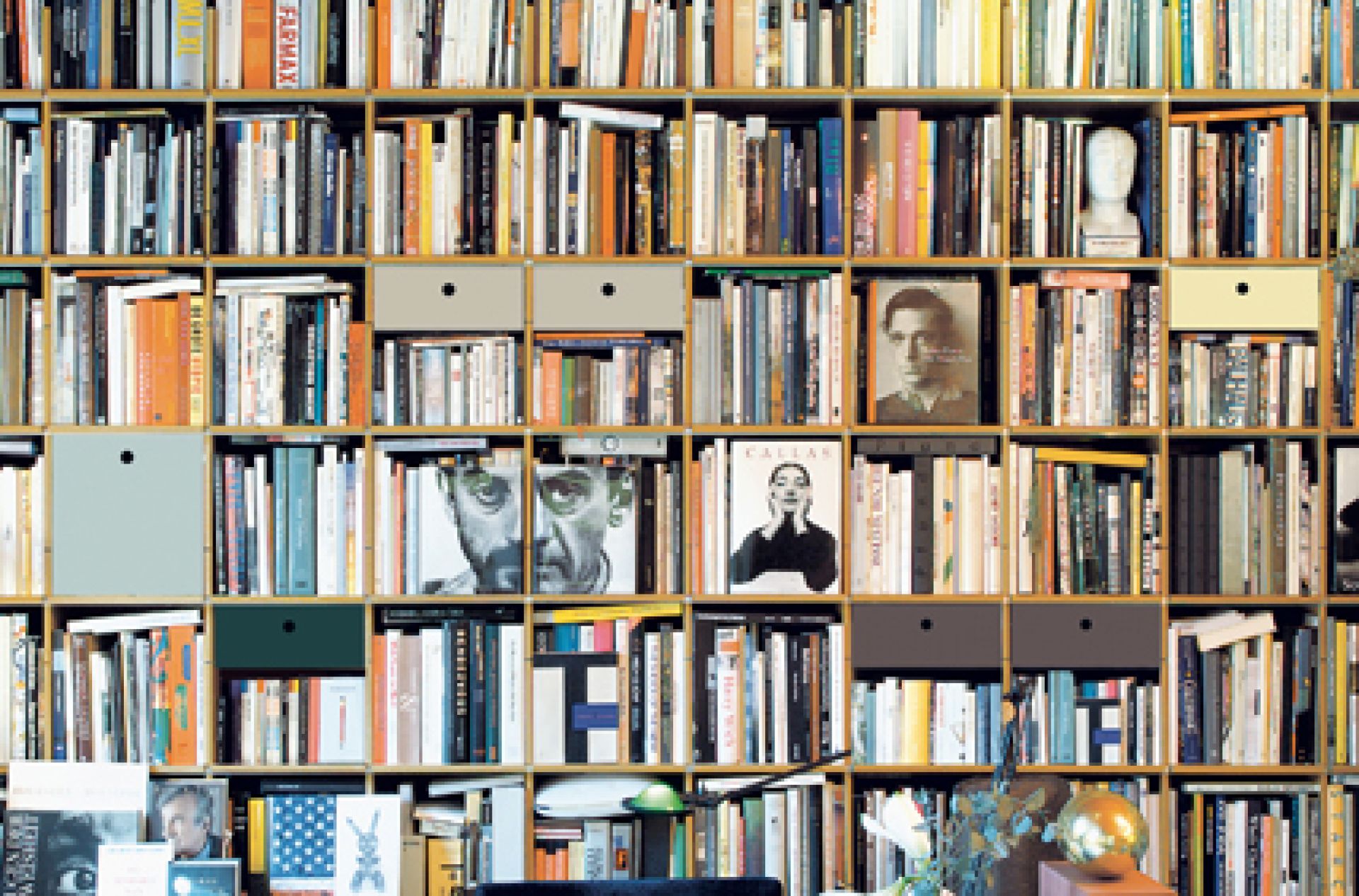 Volles Bücherregal, FNP Regal von Moormann, mit Büchern und Schubladen in verschiedenen Farben.